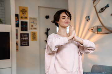 Attractive healthy calm young woman meditating