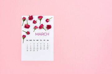 Happy Womens Day. Little pink roses on march calendar leaf over pink pastel background