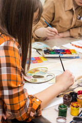 Creativity workshop, art education. Creative hobby. Art lesson. Female hand with paintbrush