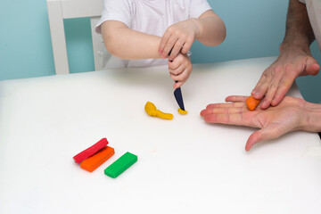Boy playing with plasticine. Child molding modeling clay. Fine arts for toddler. Art Lesson in daycare.