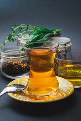 Traditional tea in a glass, tea ceremony with aromatic herbs, mint and honey.