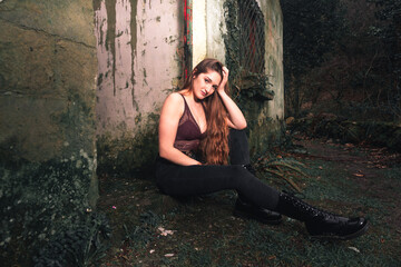 Young caucasian woman in the forest with a abandoned building behind