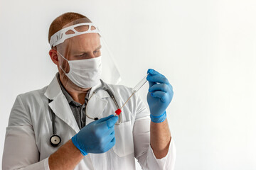 Fototapeta na wymiar Physician in uniform, protective mask, face shield and gloves with cotton swab and test tube. Medic in protective outfit opening sterile package of tube and swab to take sample on Coronavirus.