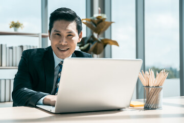 Smart asian businessman working with laptop at office.