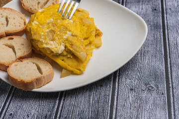 Spanish omelette with potatoes and onion, typical Spanish cuisine. Spanish tortilla. Dark wood background