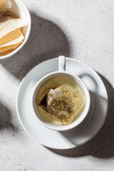 Fresh herbal tea in white cup. Herbal tea bags, top view.