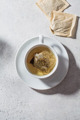 Fresh herbal tea in white cup. Herbal tea bags, top view.