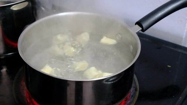 Boiling gnocchi in a large steel pan. A traditional italian food