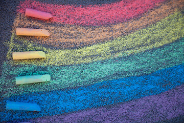 Chalk drawing. A rainbow painted on the asphalt with multicolored large crayons