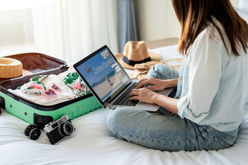 Young women planning summer vacation trip and searching information or booking hotel on laptop,...