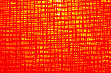 Red lattice texture with interior lighting. Background image. Backlight in fiery yellow. 