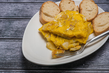 Spanish omelette with potatoes and onion, typical Spanish cuisine. Spanish tortilla. Dark wood background