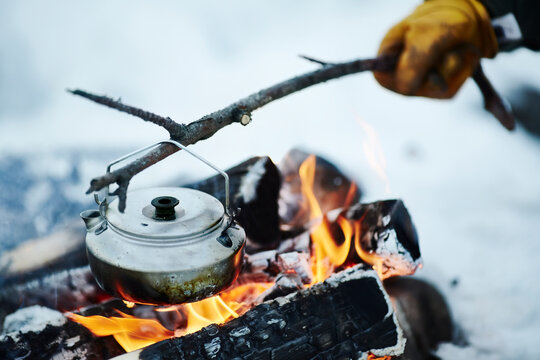 Kettle on stick over campfire
