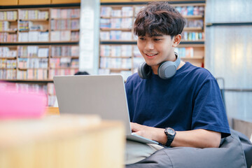 Young collage student using computer and mobile device studying online.
