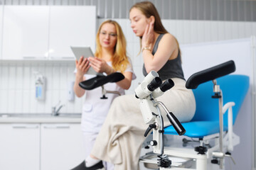 colposcope close-up on the background of a blurry image of a gynecologist and a patient in a blue gynecological chair. Women's consultation