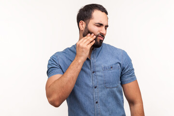 Sad unhappy man touching cheek feeling tooth pain and gums inflammation, oral cavity problems, need...