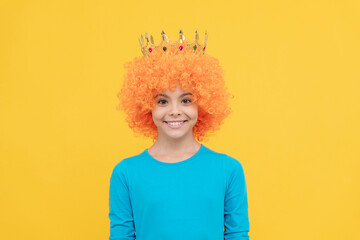 girls birthday party. happy funny kid in curly wig and crown. imagine herself a queen.