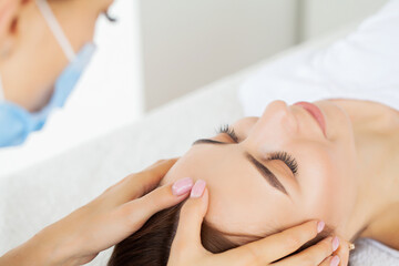 Naklejka premium Beautiful young woman relaxing with hand massage at beauty spa salon.