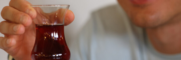 Man's hand holds glass of dark liquid in his hands. Treatment for alcoholism concept