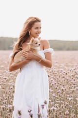 Fototapeta na wymiar dog long-haired Chihuahua in the hands of a girl in the field