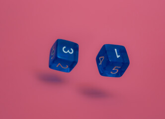 Two blue dices fall on pink background.