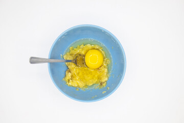 Step 3. Add one egg to banana mixture and mix. Cooking banana pancakes without flour tutorial. Step by step recipe. Top view white background. Gluten free breakfast.