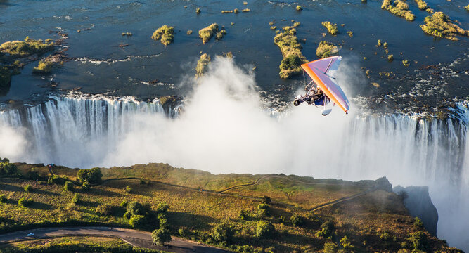 Tourists fly over the Victoria Falls on the trikes. Africa. Zambia. Victoria Falls.