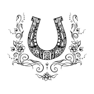 Ornate horseshoe talisman with romantic flowers and flourishes around, sketchy ink vignette, hand drawn design element. Isolated grungy tattoo, zentangle style symbol of luck for prints, web
