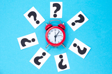 a question mark on a white sheet and a red alarm clock . FAQ frequency asked questions, Answer, Information and Brainstorming Concepts