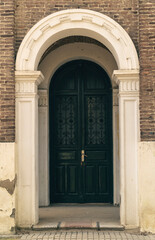 Fototapeta na wymiar puerta verde en portal con marco blanco