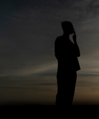 silueta negra de joven fumando un cigarro