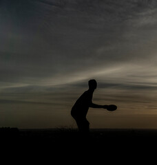 silueta negra de hombre jugando frisbee