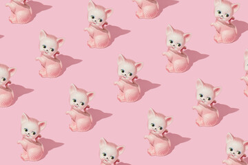 Creative pattern made with cat or kitten vintage figurine on pastel pink background. Retro aesthetic idea. Romantic vintage concept.