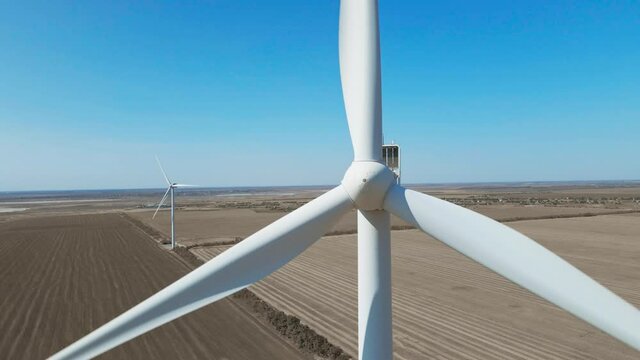 Aerial zoom out view of Wind Turbine Farm on agriculture fields in Ukraine. eco friendly and renewable power electric