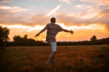 Man in the field at sunset enjoy life smiling, happy with victory,  good news, screams, freedom.