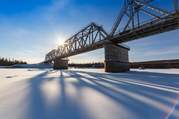 Fototapeta na wymiar Railway bridge in the background of the winter evening sun
