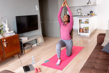 Young african america woman at home doing exercise.