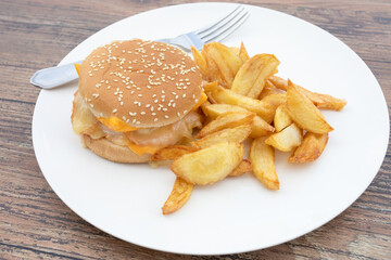 burger au saumon et frites dans une assiette	
