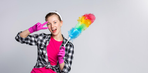Banner- long format. Woman with a colorful brush , finish to clean the dust. Peace and victory sign on gray background. 