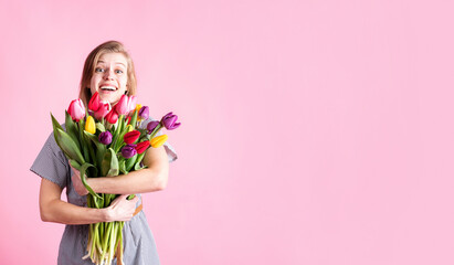 Happy young woman holding bouquet of fresh tulips isolated on pink background