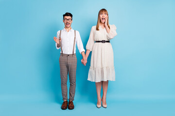 Photo of sweet impressed couple wear white outfit holding arms together hand cheek cheekbone isolated blue color background