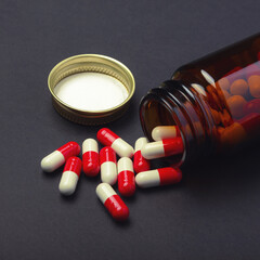 Red anf white pills on balck table. Medicine background.