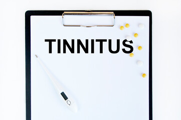 TinnitUS, a thermometer and yellow tablets, are on the letter tablet.