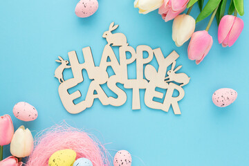 Happy Easter wooden sign with tulips on a blue background