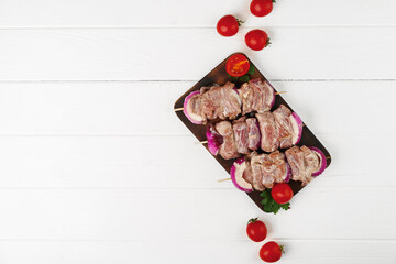 Raw marinated kebab on skewers on wooden background