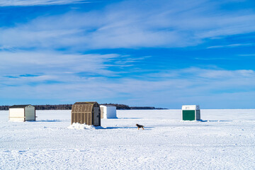 Ice fishing on a frozen harbor along the coast of Prince Edward Island, Canada.
