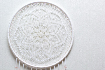 Handmade dream catcher with feathers threads and beads rope hanging on white background