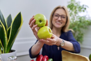Fototapeta na wymiar Green apples in hands of woman nutritionist, healthy eating