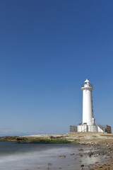 Fototapeta na wymiar 浜辺にある白い灯台
