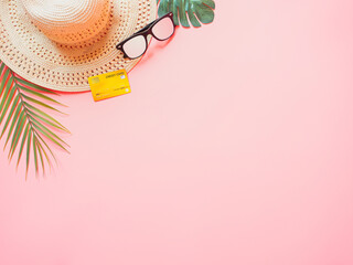 summer accessories concept from credit card and summer collection on pastel red background.